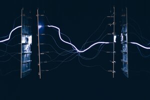 A closeup shot of electrical chipsets transmitting energy through each other on a dark background