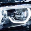 Luminous car headlight. Macro photo of automobile exterior detail as industrial and technological design.