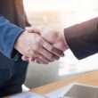 Two confident business man shaking hands during a meeting in the office, success, dealing, greeting and partner concept