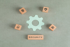 Conceptual of security with wooden blocks, paper settings icon on sage color background flat lay. horizontal image