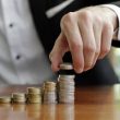 Closeup shot of a businessman's hands counting stacks of coins after business success