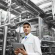 Technologist with grey tablet in his hands make a set up of the production line