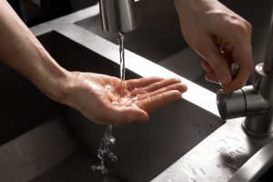 A hand under a running water tap