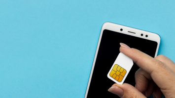 A SIM card held over a phone