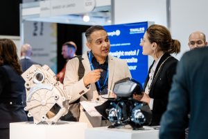 Two individuals discussing new developments at AE 2026