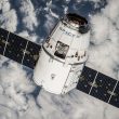 A communications satellite in orbit above Earth, representing the non-terrestrial network connectivity used in satellite IoT deployments