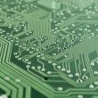 Close-up of a printed circuit board showing microchips and soldered connections, representing a chip-level secure element providing a hardware root of trust in IoT devices