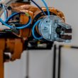 Close-up of an industrial robot arm gripper on a factory production line, representing the industrial automation and control systems covered by IEC 62443 cybersecurity standards