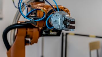Close-up of an industrial robot arm gripper on a factory production line, representing the industrial automation and control systems covered by IEC 62443 cybersecurity standards